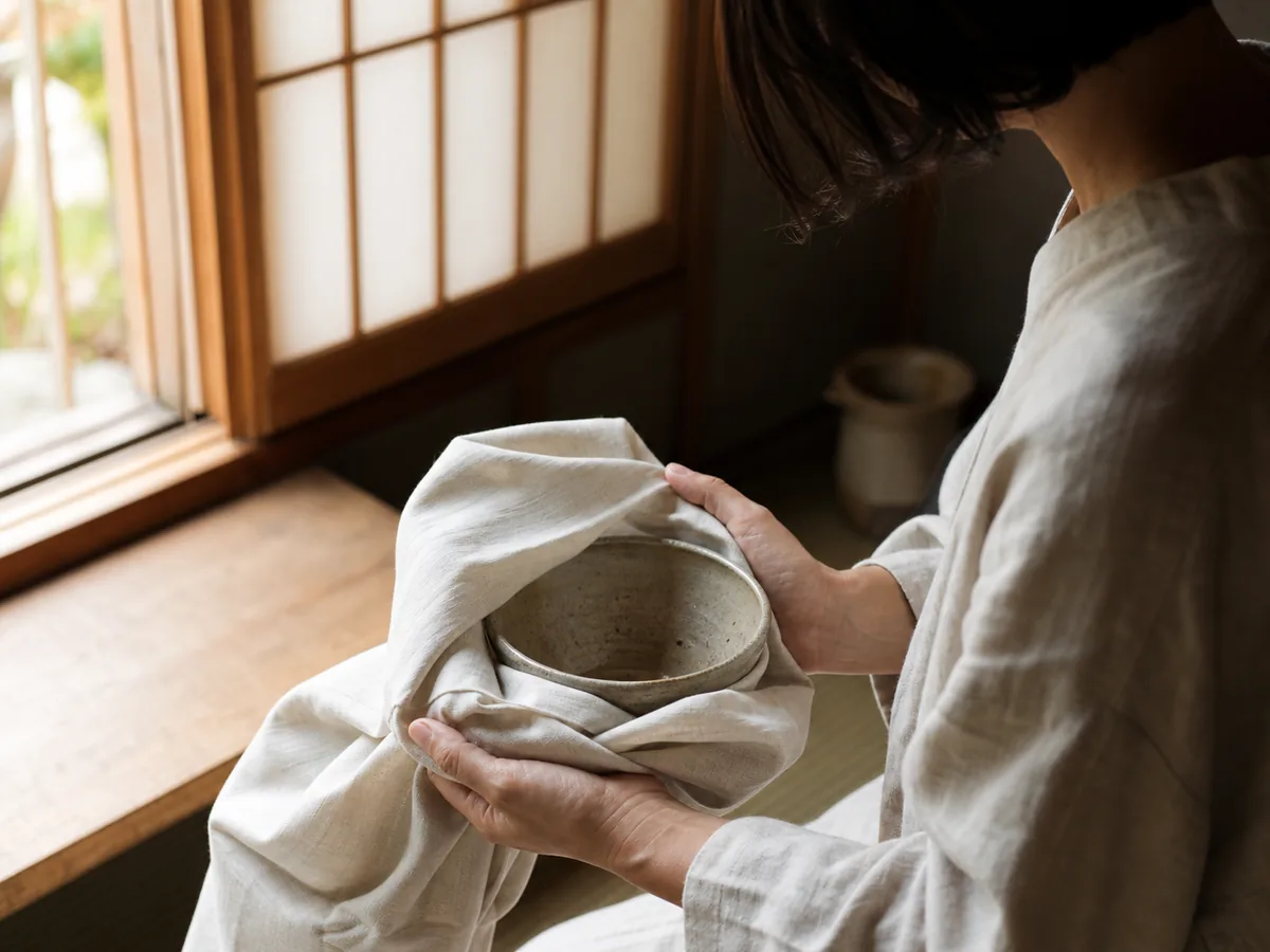 器を柔らかい布で包む手元